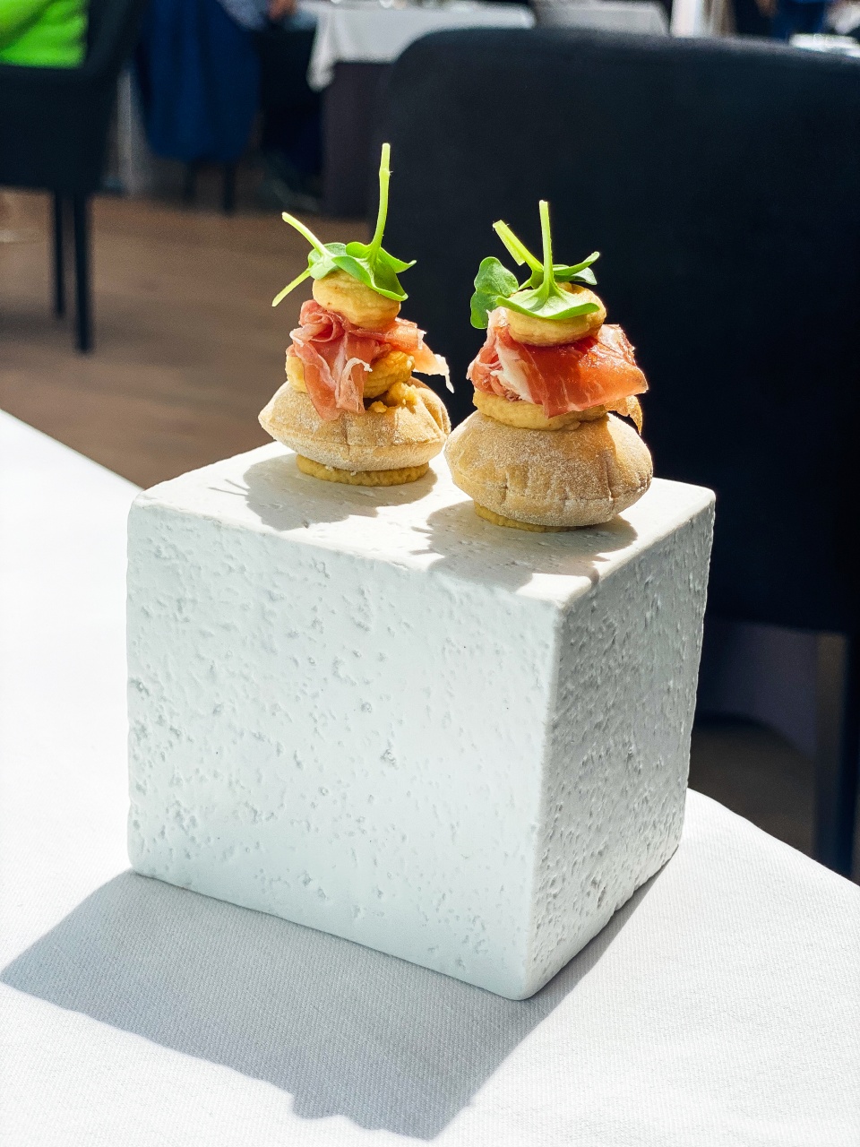 A beautiful presentation of refined appetizers on an elegant platter at De Bakermat restaurant, with each bite carefully prepared to offer a burst of flavor and texture."
