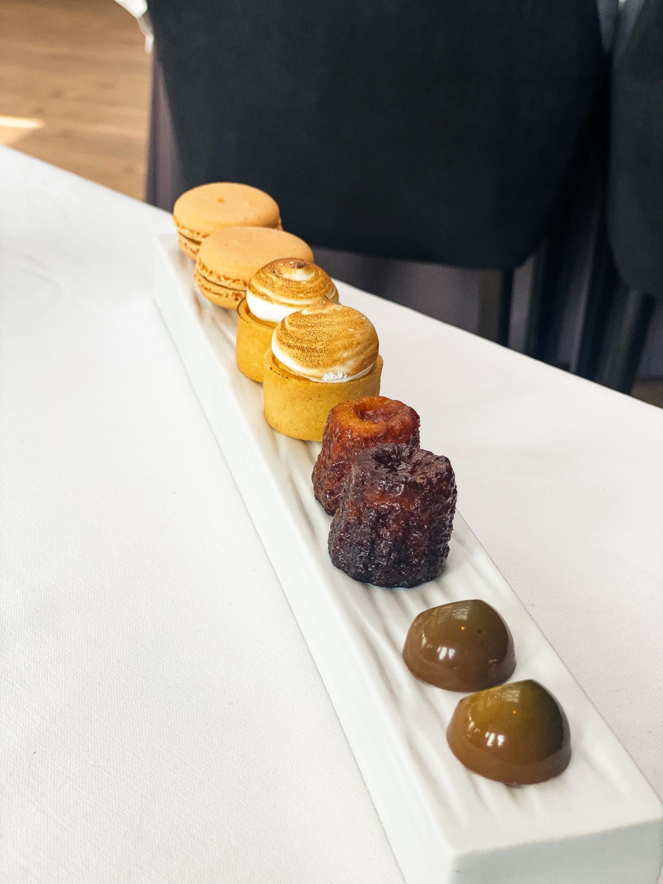 An enticing selection of small desserts, pastries and chocolates, beautifully presented on a platter, serving as a sweet ending to a culinary experience at De Bakermat restaurant.