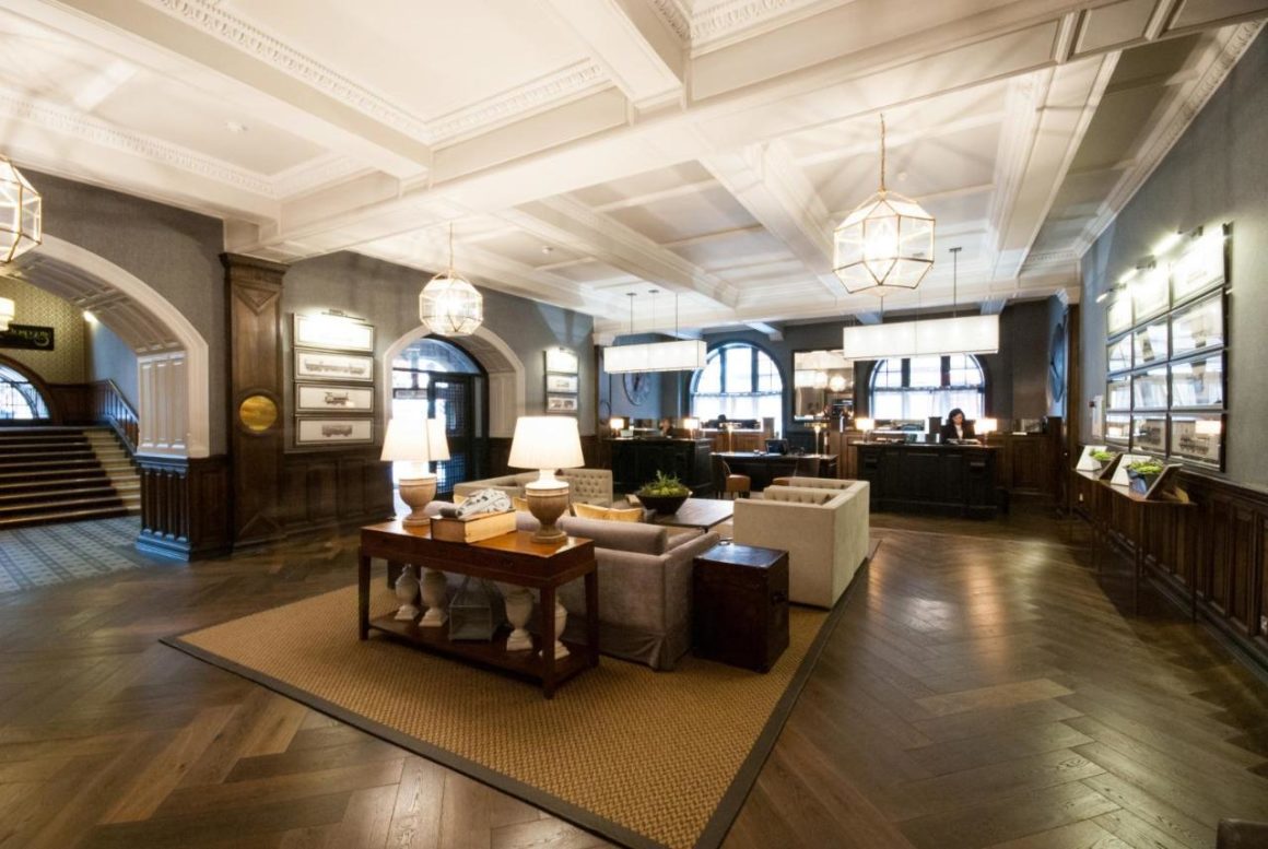 Een prachtig beeld van de lobby van het Grand Central Hotel in Glasgow, met ingewikkelde architecturale details, weelderige kroonluchters en een uitnodigende zithoek die ouderwetse charme en elegantie uitstraalt.
