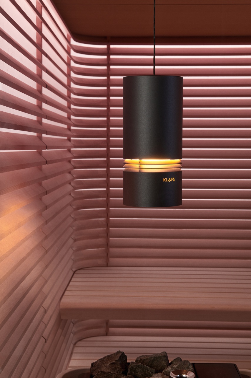 The second image shows a detail of a sauna. The pink wood paneling and simple accessories create a calming and relaxing atmosphere.
