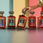 The five Disaronno 500-year limited edition bottles displayed in a vibrant setting, with a hand gently touching the Dolce Vita bottle.